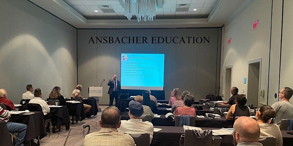 Attorney Barry Ansbacher stands at the front of a conference room, speaking to an audience.